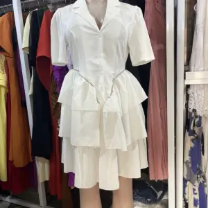 A-line tiered Dress | a Ruffled Shirt Dress with a Lapel Collar and short sleeves, tapering into a multi-layered, tiered skirt that creates a flared, voluminous silhouette.