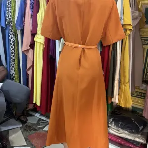 Tailored Silhouette with a Collared neckline, short sleeves, and a matching belt