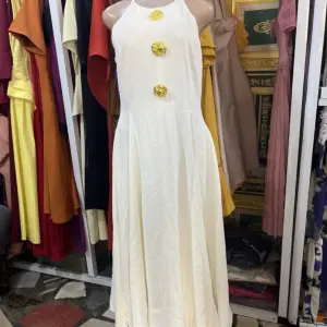 A-line Silhouette and three large yellow floral or button-like embellishments down the center.