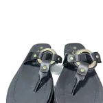 black wedge platform and distinctive gold-tone metal hardware on the T-strap