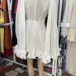 Ana Radu pleated-cape Mini Dress, featuring white pleated Fabric, cape sleeves, and a ruffled hem.