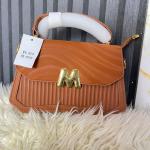 Identified by its gold M-shaped embellishment is a designer-inspired crossbody bag