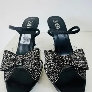 Zara Bow High Heel Sandals in a diamante-encrusted bow on the instep and a side buckle.